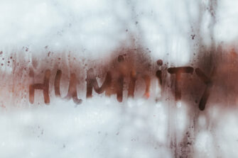 Humidity word written on wet window with condensate